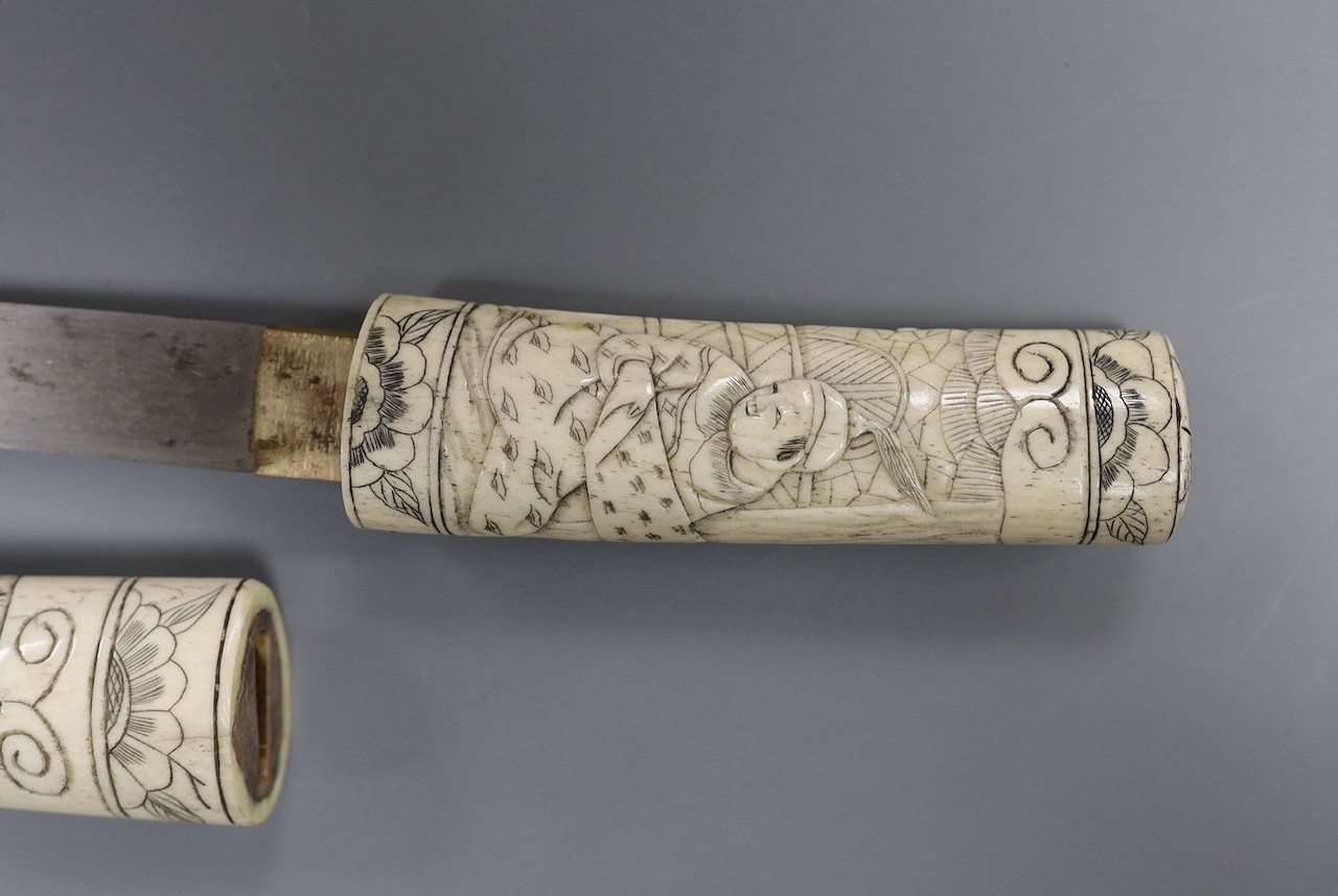 A Japanese carved bone tanto, c.1900, carved with numerous figures, overall 36cm